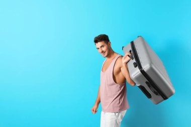 Bavul renk arka plan üzerinde olan genç adam. Metin için yer