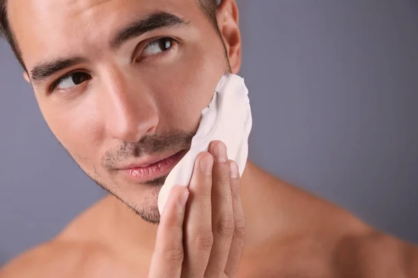 Bello Giovane Uomo Che Applica Schiuma Barba Sfondo Colore — Foto Stock