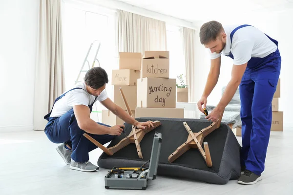 Male Movers Assembling Sofa New House — Stock Photo, Image