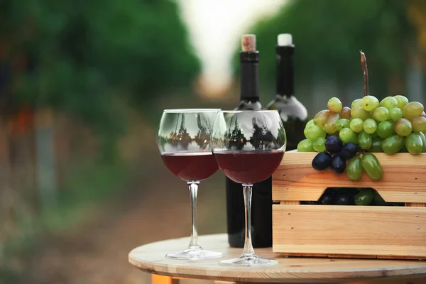 Bottiglie Calici Vino Rosso Con Uva Fresca Sul Tavolo Legno — Foto Stock