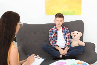 Çocuk psikoloğu ofiste bir çocukla çalışıyor.