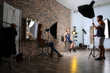 Professional team working with model in photo studio clipart