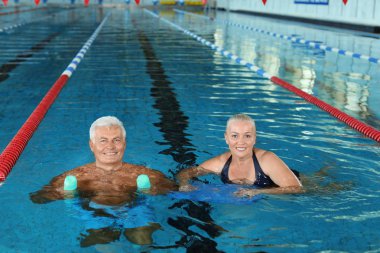 Sportif üst düzey çift kapalı yüzme havuzunda egzersizleri yapıyor