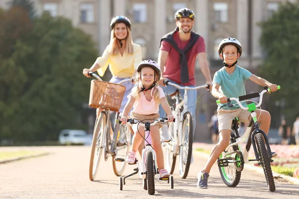 Happy family riding bicycles outdoors on summer day