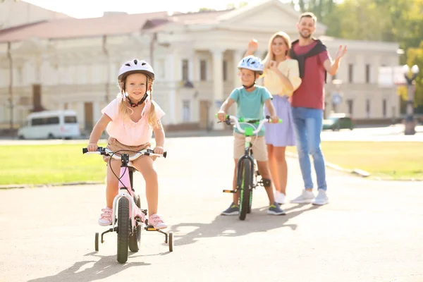 Des Parents Heureux Apprenant Aux Enfants Faire Vélo Extérieur — Photo