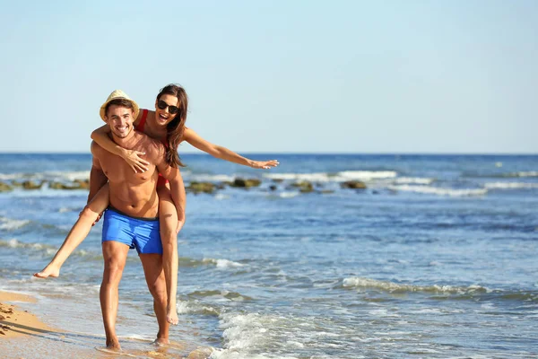 晴れた日にビーチで楽しんで幸せな若いカップル — ストック写真