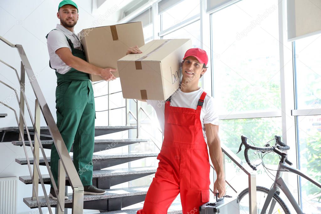 Male movers unloading boxes from van outdoors