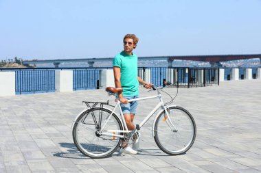 Güneşli günü açık havada bisiklet ile yakışıklı genç