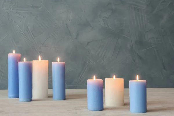 Brennende Kerzen Auf Tisch Vor Farbiger Wand Mit Platz Für — Stockfoto