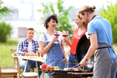 Genç çift açık havada mangal yapıyor.