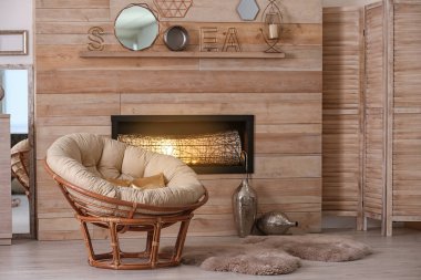Cozy living room interior with comfortable papasan chair and decorative fireplace clipart