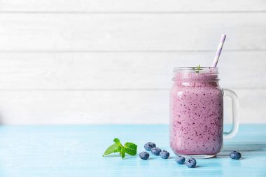 Açık renkli metin için yer ile karşı masada mason kavanoza lezzetli blueberry smoothie
