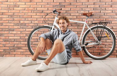 Duvara karşı bisiklet ile yakışıklı adam