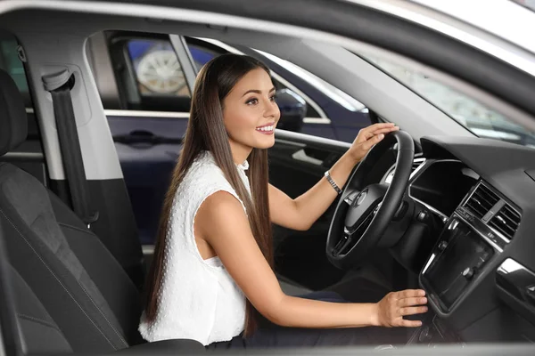 stock image Young woman testing new car in salon