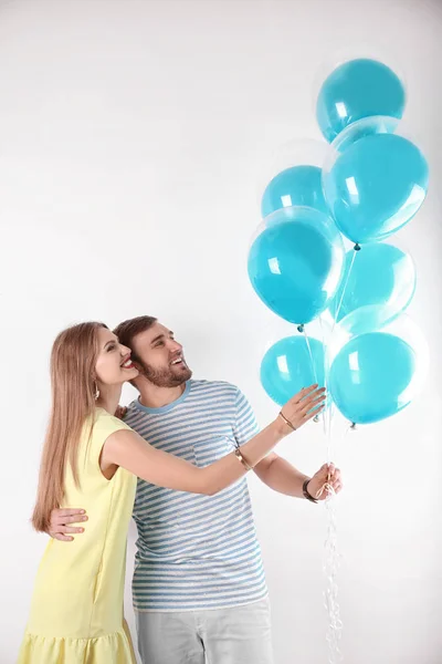 Junges Paar Mit Luftballons Auf Weißem Hintergrund — Stockfoto