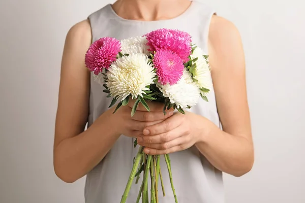 Kvinna Med Vackra Aster Blombukett Mot Ljus Bakgrund — Stockfoto