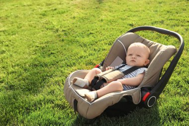 Yeşil çimenlerin üzerinde çocuk Emanet koltukta bebek