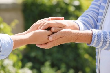 Bulanık arka planda ellere yardım etmek, yakın çekim. Yaşlılara bakım kavramı