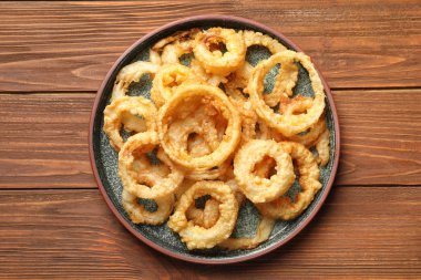 Ev yapımı çıtır çıtır kızarmış soğan halkaları üzerinde ahşap masa, üstten görünüm