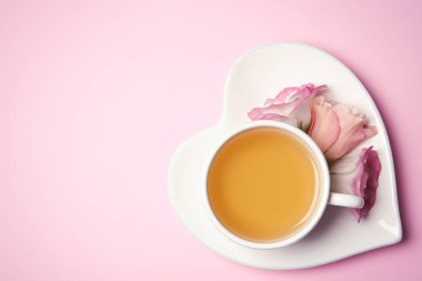 Fincan çay ve çiçek renk arka plan, metin için yer ile üstten görünüm