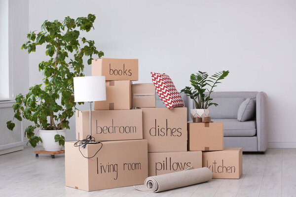 Pile of moving boxes and household stuff in living room