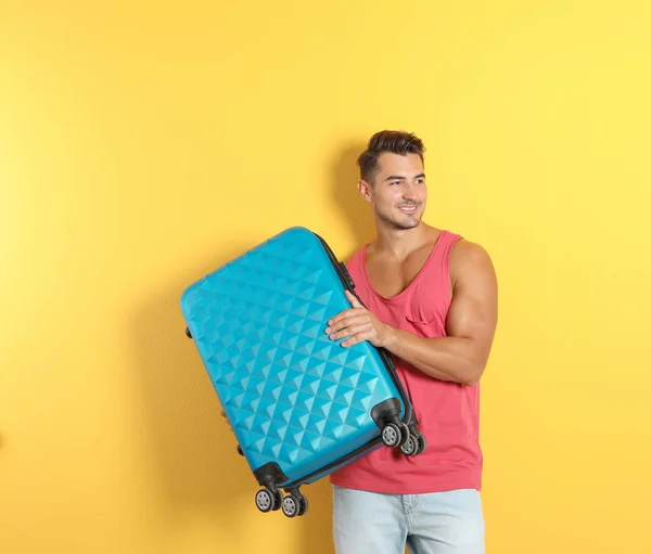 Junger Mann Mit Koffer Auf Farbigem Hintergrund — Stockfoto