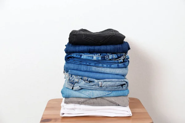 Stapel Van Verschillende Jeans Tafel Tegen Witte Achtergrond — Stockfoto