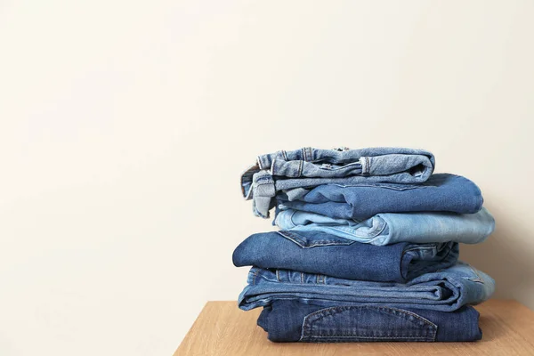 Pilha Jeans Diferentes Mesa Contra Fundo Claro Espaço Para Texto — Fotografia de Stock