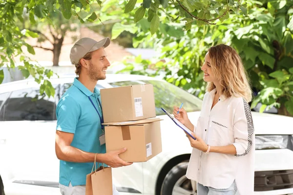 Junge Frau Unterschreibt Dokumente Nachdem Sie Pakete Von Kurier Freien — Stockfoto