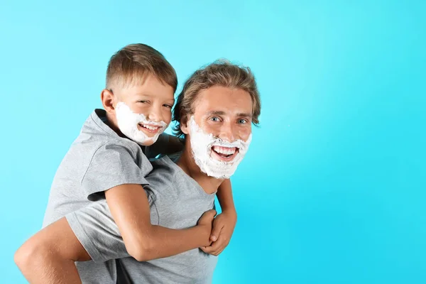 Pai Filho Brincando Com Espuma Barbear Rostos Contra Fundo Cor — Fotografia de Stock