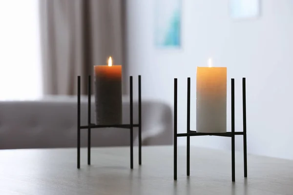 Burning candles on table in living room