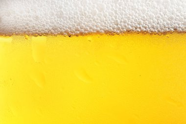 Köpüklü bir bardak lezzetli bira, yakın plan.