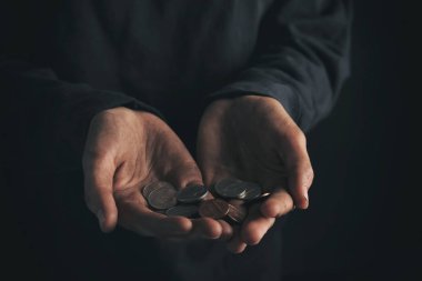 Koyu arka plan üzerinde closeup paraları tutan zavallı kadın
