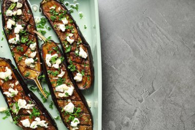 Gri arka plan, üstten görünüm üzerinde kızarmış patlıcan dilimleri ile pişirme çanağı. Metin için yer