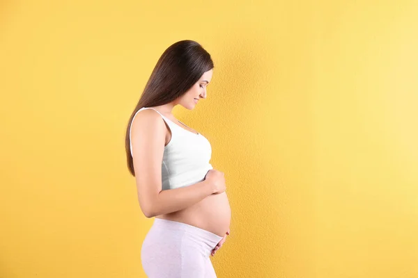 Bela Mulher Grávida Mãos Dadas Barriga Contra Fundo Cor Espaço — Fotografia de Stock