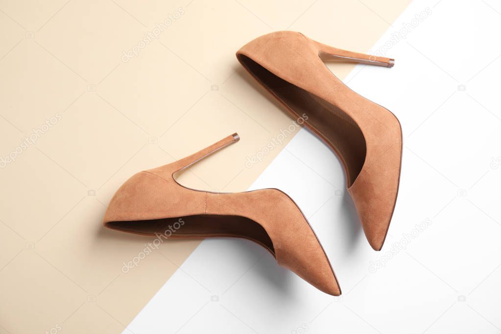Pair of beautiful shoes on color background, top view