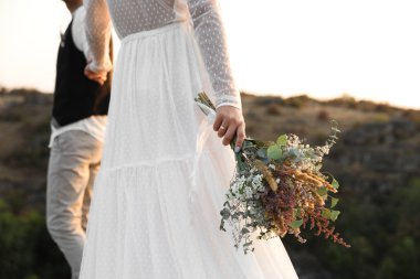 Güzel alan buket açık havada, closeup ile mutlu yeni evliler