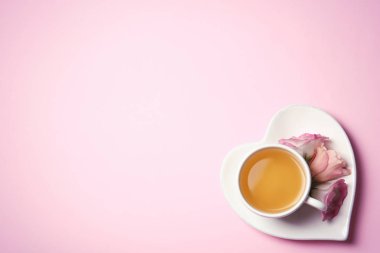 Fincan çay ve çiçek renk arka plan, metin için yer ile üstten görünüm