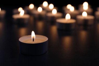 Karanlıkta masada mum yakmak, yazı için yer açmak. Cenaze sembolü