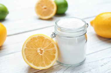 Kabartma tozu ve beyaz ahşap masa üzerinde limon ile jar