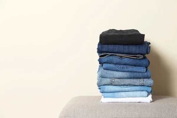 Stack Van Verschillende Jeans Ottomaanse Tegen Lichte Achtergrond Ruimte Voor — Stockfoto