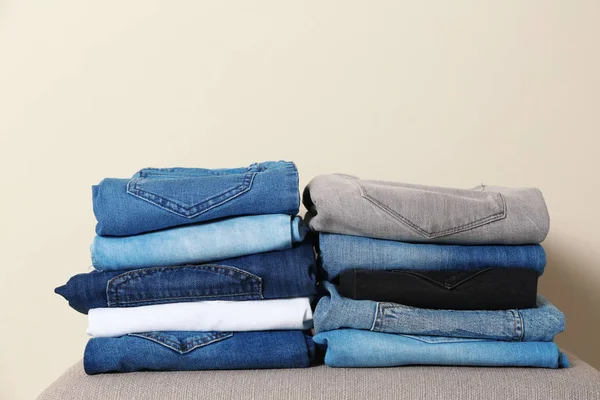 Stapel Van Verschillende Jeans Ottomaanse Tegen Lichte Achtergrond — Stockfoto