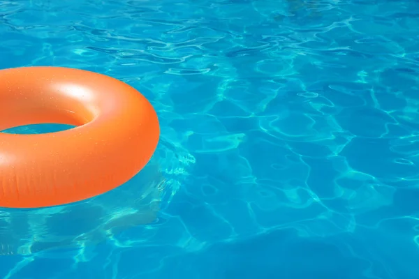 Inflatable ring floating in swimming pool on sunny day. Space for text