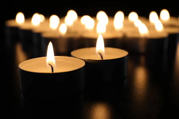 Hořící Svíčky Stole Tmě Closeup Pohřeb Symbol — Stock fotografie