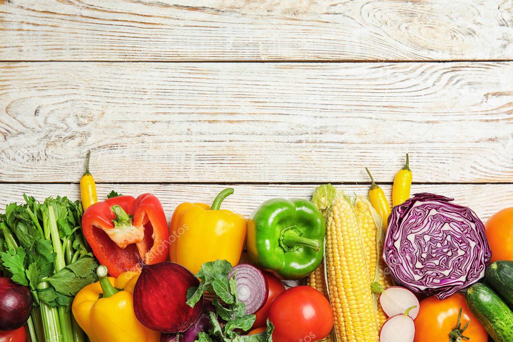 Flat lay composition with assortment of fresh vegetables on wooden background. Space for text