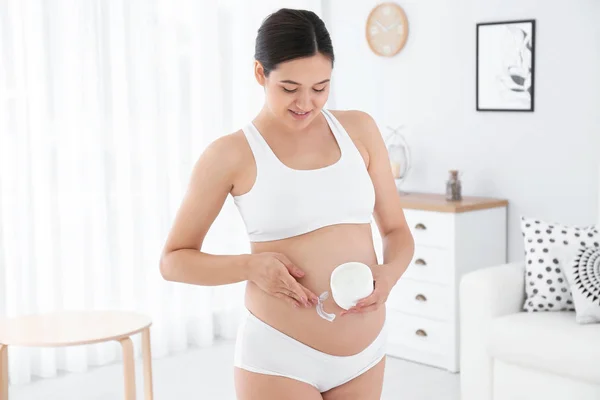 Mujer Embarazada Aplicando Crema Corporal Vientre Casa — Foto de Stock