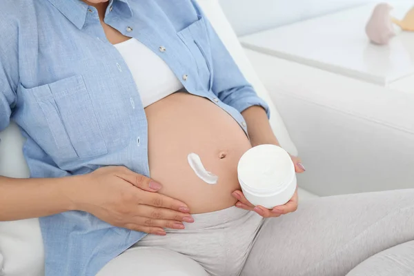 Mujer Embarazada Aplicando Crema Corporal Vientre Casa Primer Plano — Foto de Stock