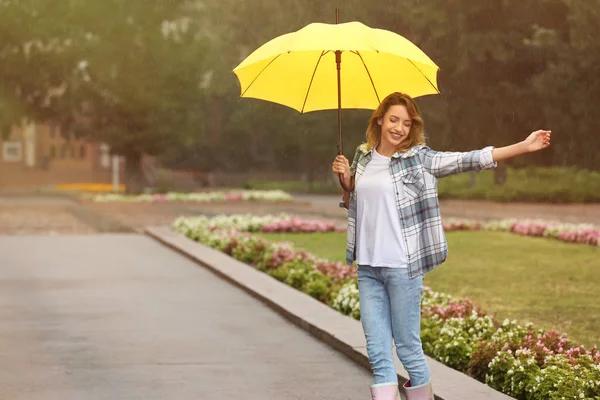 公園で雨の下で傘を持つ幸せな若い女性 — ストック写真