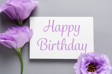 Eustoma çiçek ve gri arka plan üzerinde Happy Birthday tebrik ile kart düz yatıyordu kompozisyon