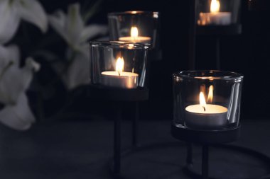Koyu arka plan üzerinde yanan mumlar. Cenaze sembolü